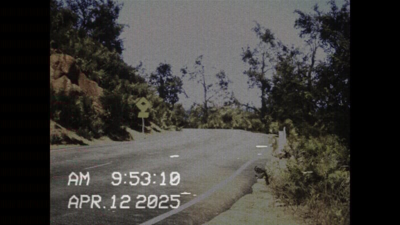 A winding road flanked by trees under a clear sky, captured in a vintage VHS style. The date "APR. 12 2025" and time "AM 9:53:10" are displayed in the lower left corner.